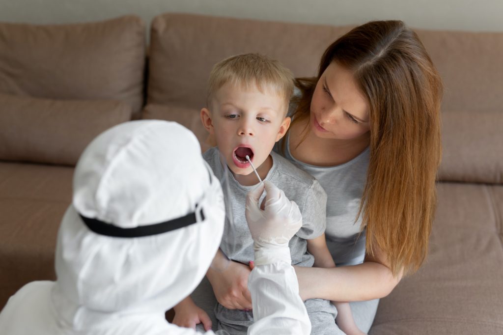 Doctor takes bud from child mouth to analyze the saliva, mucous membrane for DNA tests, COVID-19