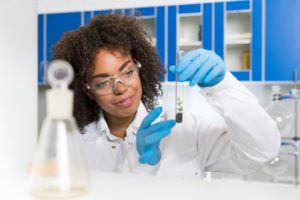 Female Laboratory Scientist Examining Plant Sample In Test Tube, Work In Genetics Lab